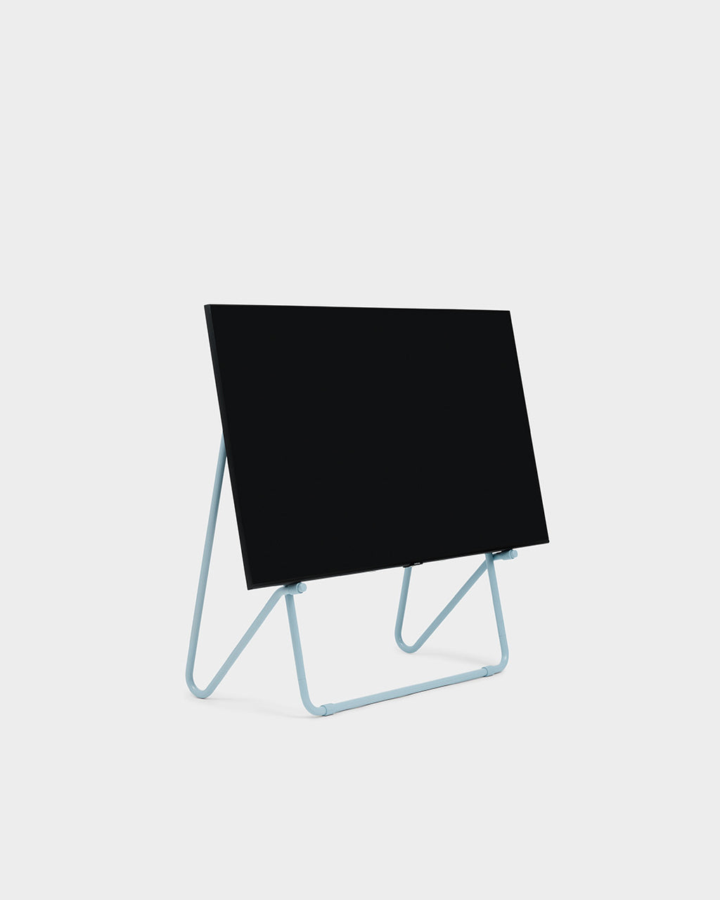 Bloom in Powder Blue (Stands Low) in studiopackshot, schuine vooraanzicht met zwart tv-paneel op lichtblauw buizenframe